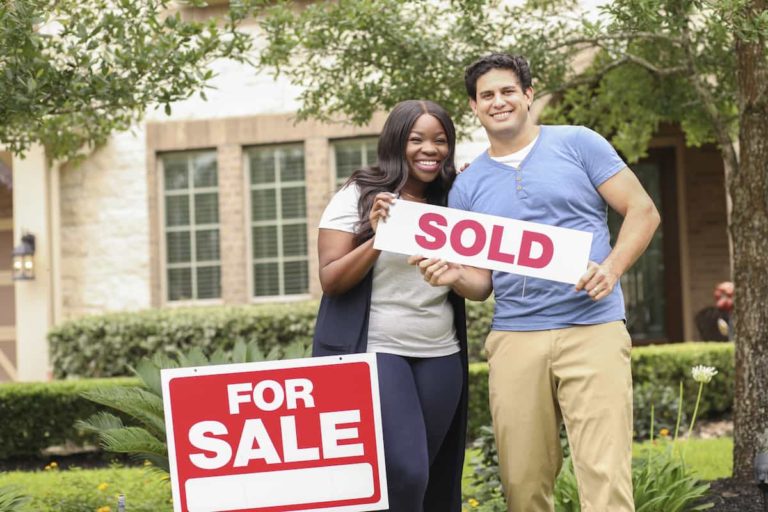 couple-holding-sold-sign